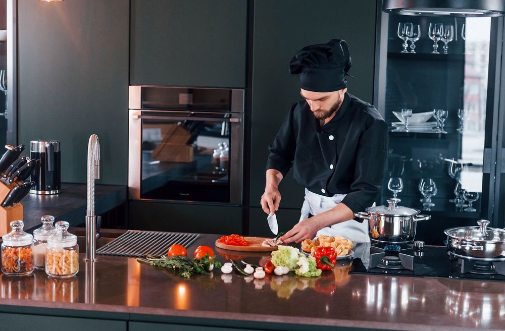Professional young chef cooks a meal in a private villa for guests on vacation in Miami.